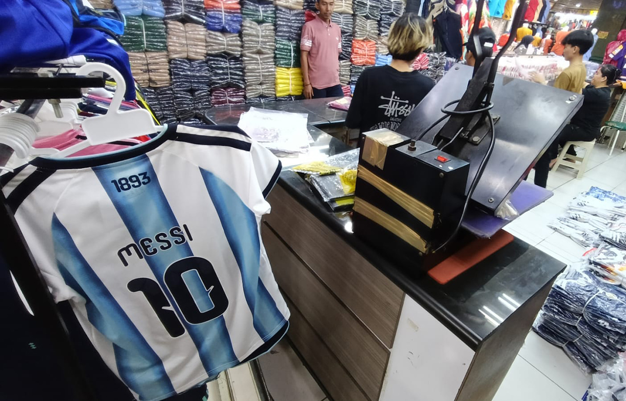 Pedagang menata replika jersey timnas sepak bola peserta Piala Dunia 2026. (Beritanasional/Oke Atmaja)