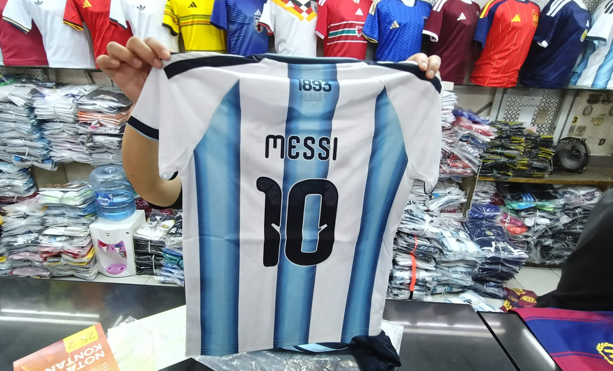 Pedagang menata replika jersey timnas sepak bola peserta Piala Dunia 2026 Amerika Serikat, Meksiko, dan Kanada.  di salah satu kios, Blok B Pasar Tanah Abang, Jakarta, Jumat(10/4/2026).  (Beritanasional.com/Oke Atmaja)