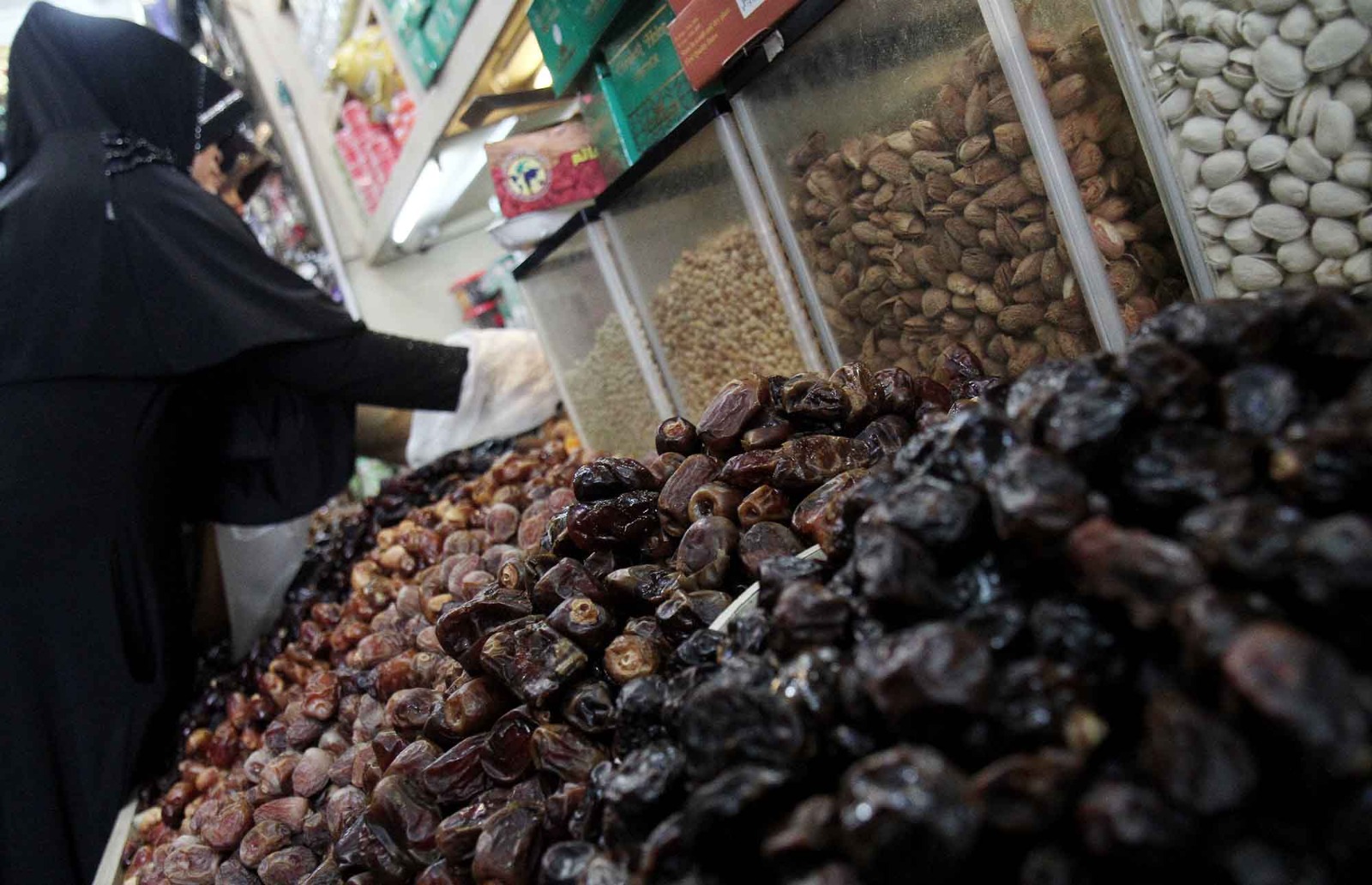 Pembeli memilih buah kurma yang dijual di salah satu toko kurma kawasan Pasar Tanah Abang, Jakarta, Kamis (28/2/2025). (Berita nasional.com/Oke Atmaja)