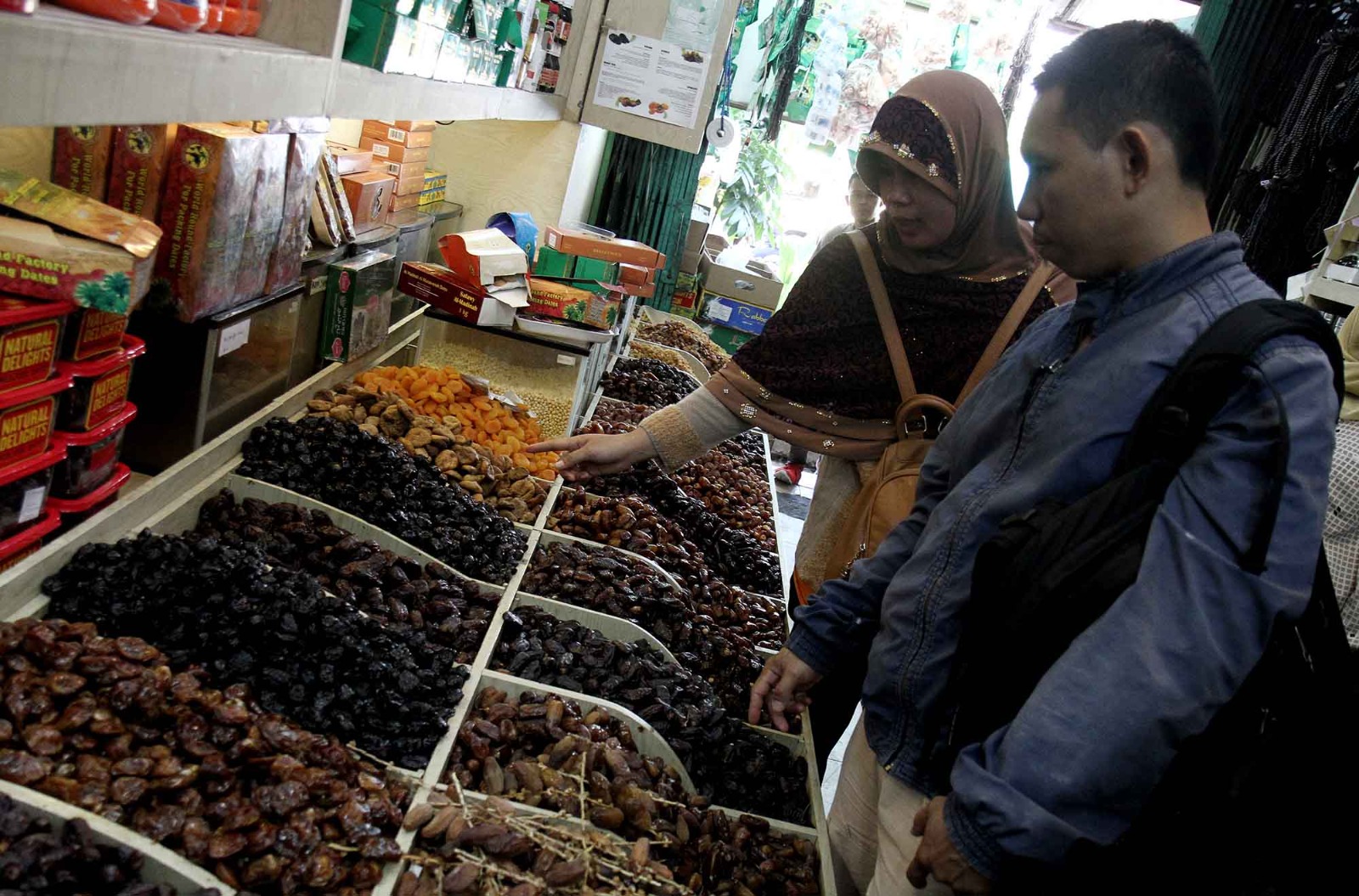 Pembeli memilih buah kurma yang dijual di salah satu toko kurma kawasan Pasar Tanah Abang, Jakarta, Kamis (28/2/2025). (Berita nasional.com/Oke Atmaja)