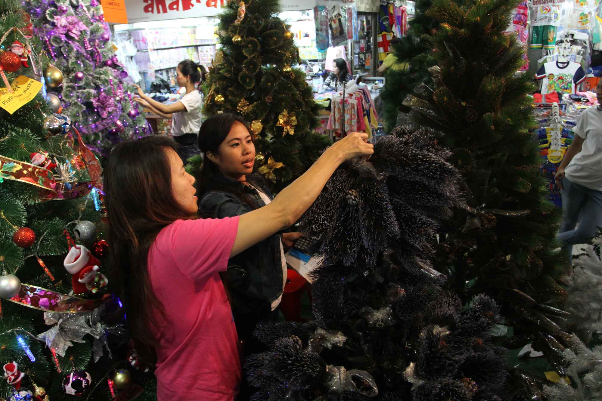 Warga memilih barang pernak-pernik natal di salah satu toko di Pasar Asemka, Jakarta, Sabtu (7/12/2024). (BeritaNasional.com/Oke Atmaja)