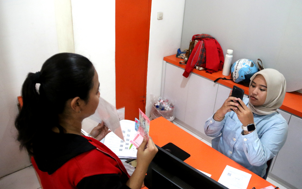 Warga penerima manfaat Bantuan Langsung Tunai Sementara Kesejahteraan Rakyat (BLTS Kesra) menunjukan uang usai melakukan pencairan dana di Kantor Pos Kebon Jeruk, Jakarta, Kamis (27/11/2025). (Beritanasional.com/Oke Atmaja)