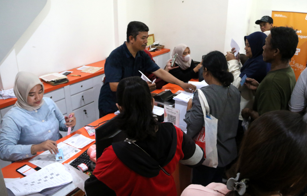 Warga penerima manfaat Bantuan Langsung Tunai Sementara Kesejahteraan Rakyat (BLTS Kesra) menunjukan uang usai melakukan pencairan dana di Kantor Pos Kebon Jeruk, Jakarta, Kamis (27/11/2025). (Beritanasional.com/Oke Atmaja)