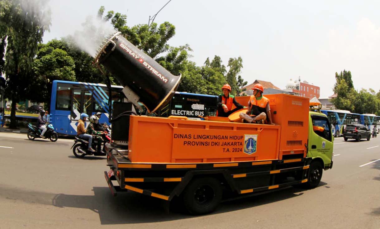 Sejumlah anggota Dinas Lingkungan Hidup (DLH) menyemprotkan air dari truk water mist di Jalan Merdeka Selatan, Jakarta, Selasa(23/09/2025). (Beritanasional.com/Oke Atmaja)