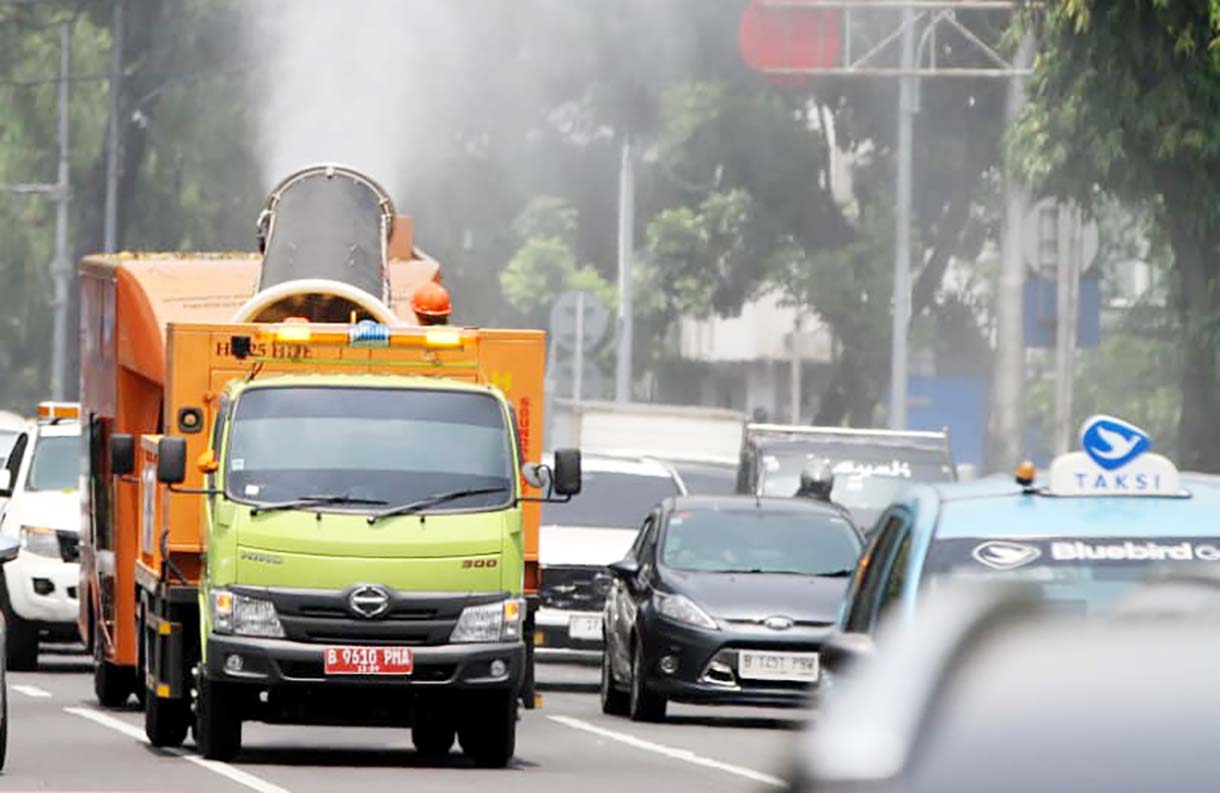 Sejumlah anggota Dinas Lingkungan Hidup (DLH) menyemprotkan air dari truk water mist di Jalan Merdeka Selatan, Jakarta, Selasa(23/09/2025). (Beritanasional.com/Oke Atmaja)