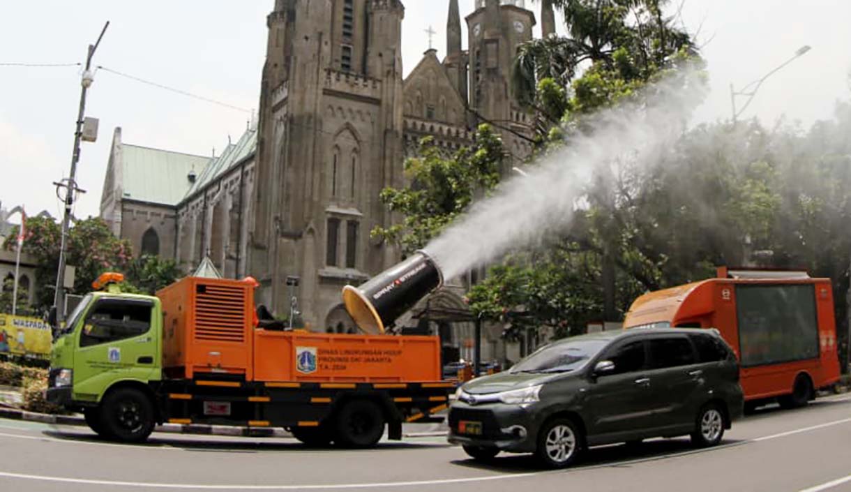 Sejumlah anggota Dinas Lingkungan Hidup (DLH) menyemprotkan air dari truk water mist di Jalan Merdeka Selatan, Jakarta, Selasa(23/09/2025). (Beritanasional.com/Oke Atmaja)