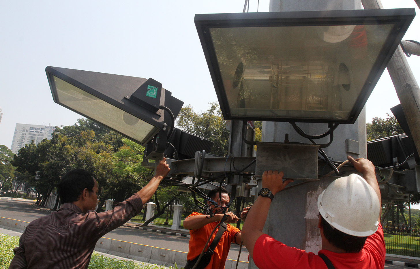 Petugas memperbaiki lampu penerangan jalan di Kawasan Monumen Nasional (Monas), Jakarta, Selasa (7/5). (BeritaNasional.com/Oke Atmaja)