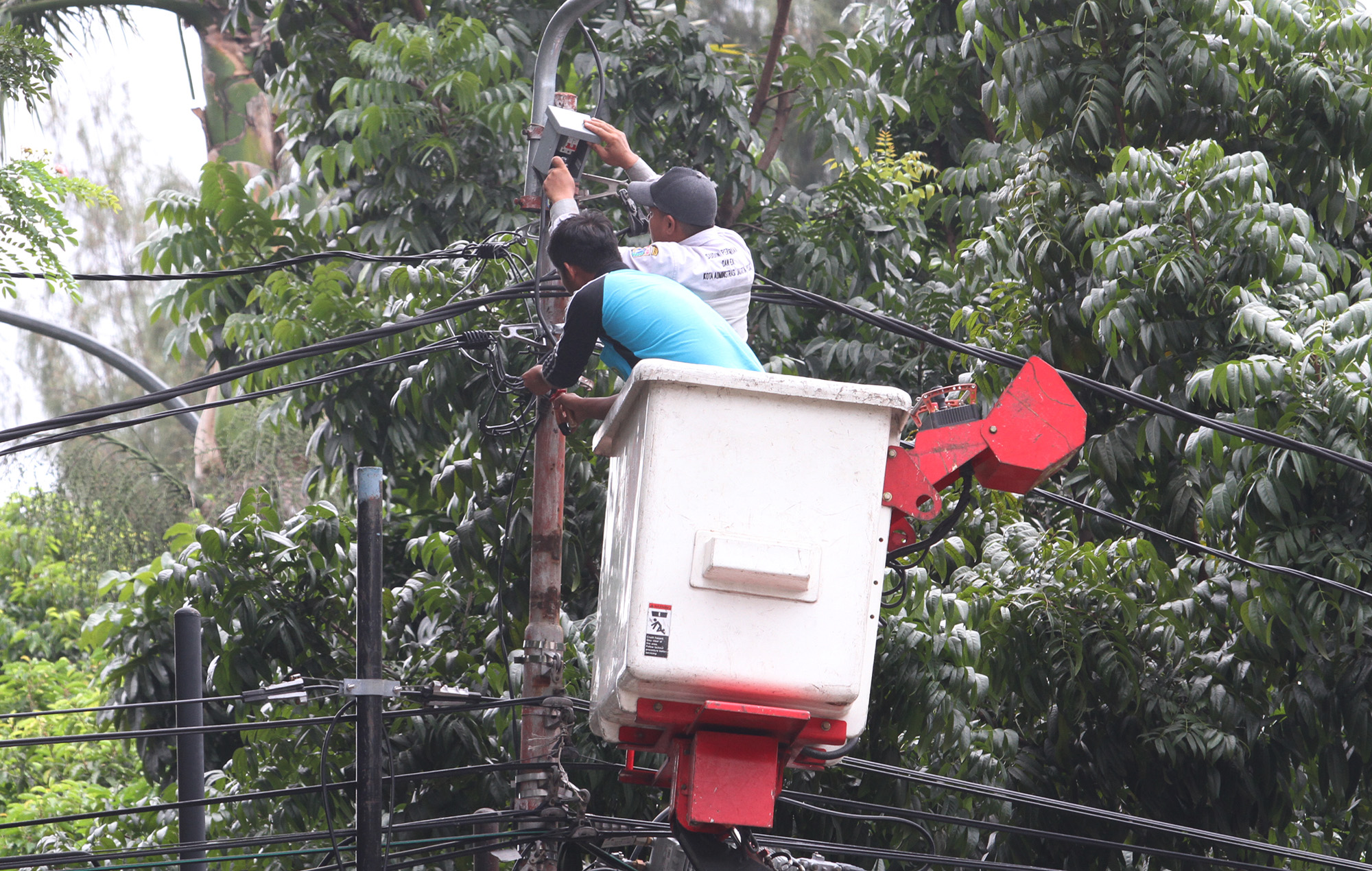 Teknisi memperbaiki lampu penerangan jalan di Kawasan Gambir, Jakarta, Selasa (2/7). (BeritaNasional.com/HO/Oke Atmaja)