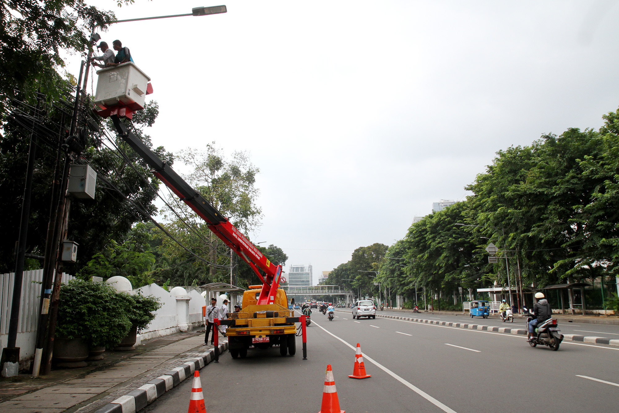 Teknisi memperbaiki lampu penerangan jalan di Kawasan Gambir, Jakarta, Selasa (2/7). (BeritaNasional.com/HO/Oke Atmaja)