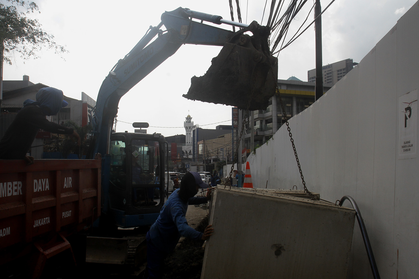 Petugas menggunakan alat berat mengeruk galian untuk pemasangan boks saluran drainase saat perbaikan saluran air di Jalan Benhil,Jakarta, Rabu (15/5/2024).  (BeritaNasional.com/Oke Atmaja)