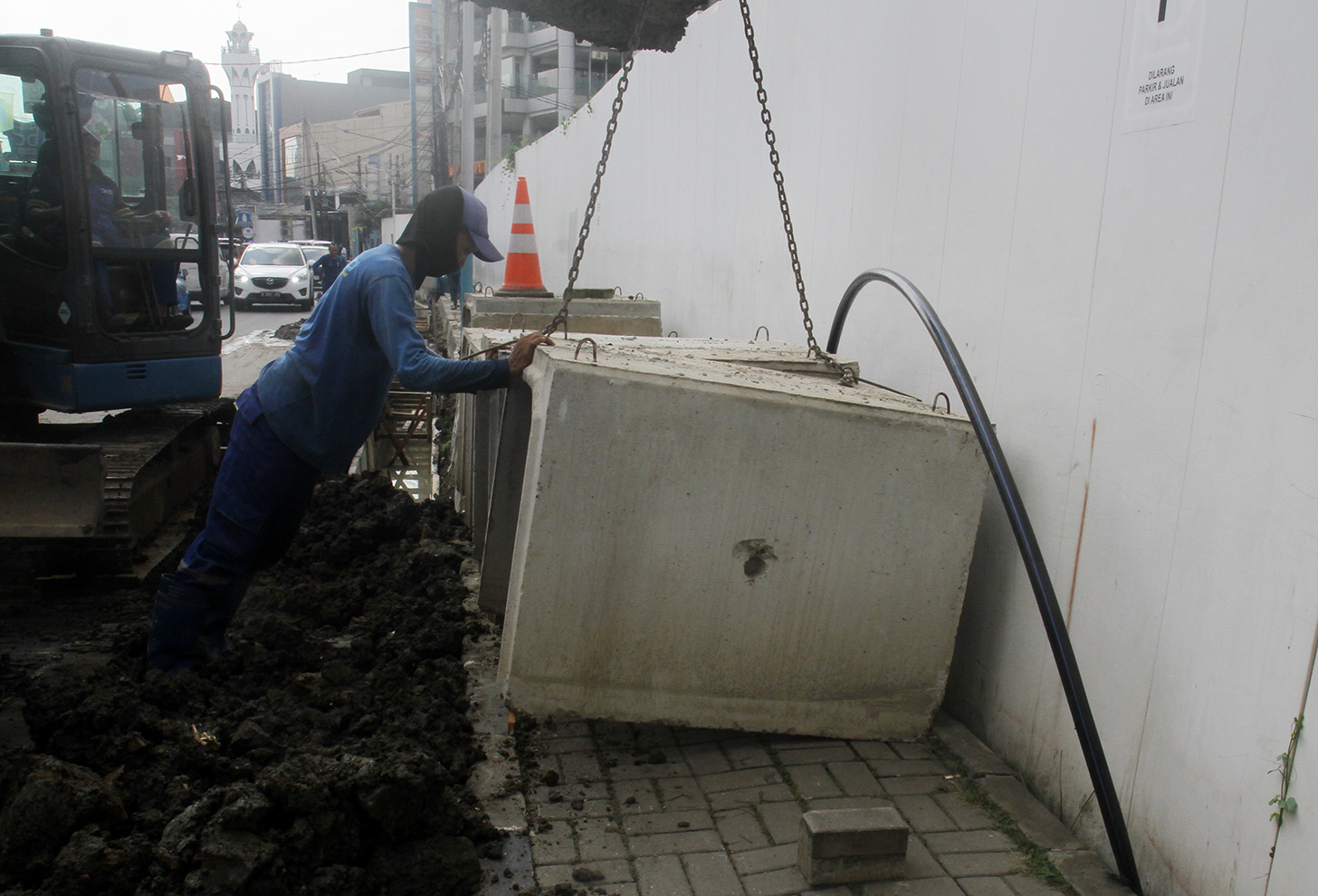 Petugas menggunakan alat berat mengeruk galian untuk pemasangan boks saluran drainase saat perbaikan saluran air di Jalan Benhil,Jakarta, Rabu (15/5/2024).  (BeritaNasional.com/Oke Atmaja)