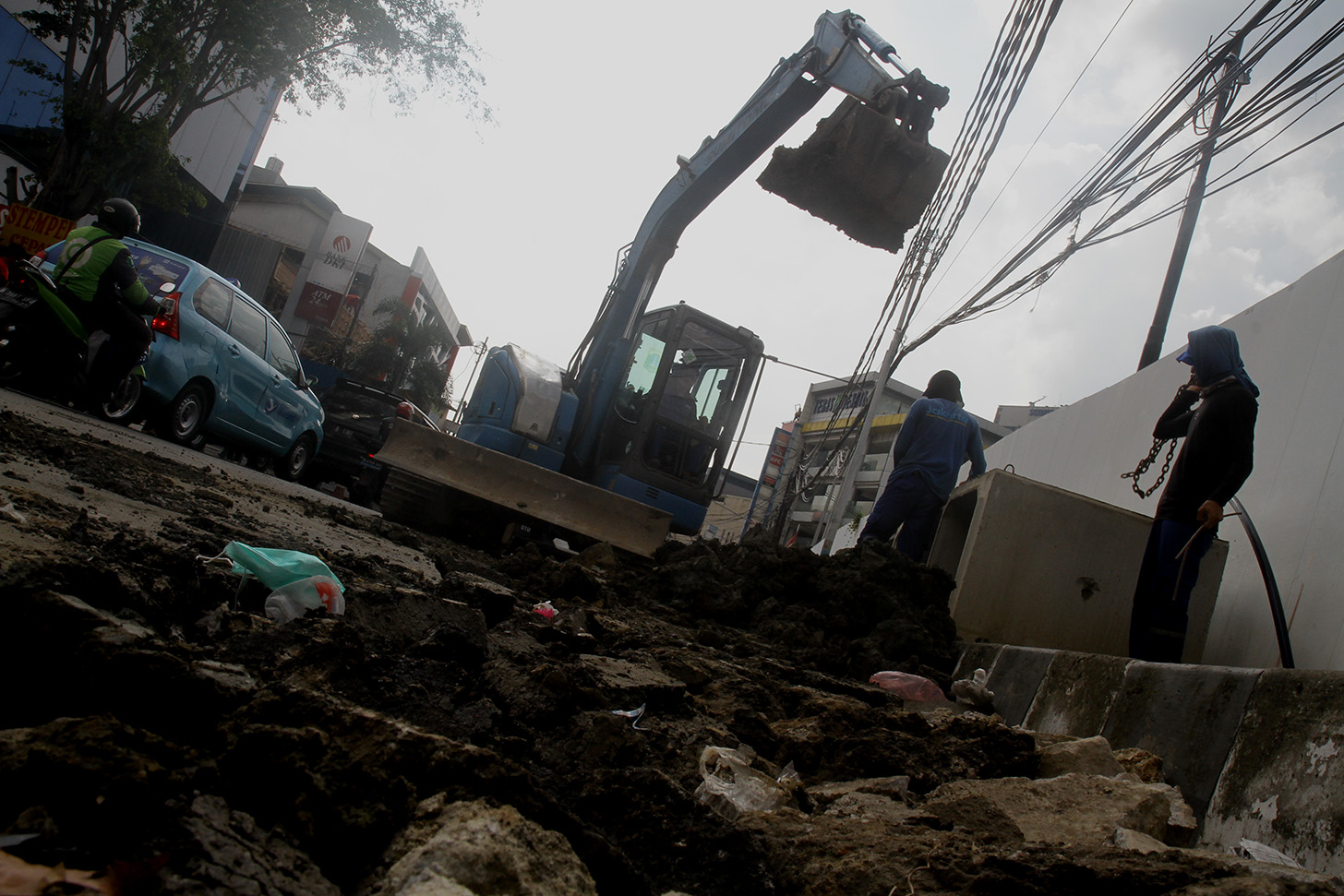 Petugas menggunakan alat berat mengeruk galian untuk pemasangan boks saluran drainase saat perbaikan saluran air di Jalan Benhil,Jakarta, Rabu (15/5/2024).  (BeritaNasional.com/Oke Atmaja)