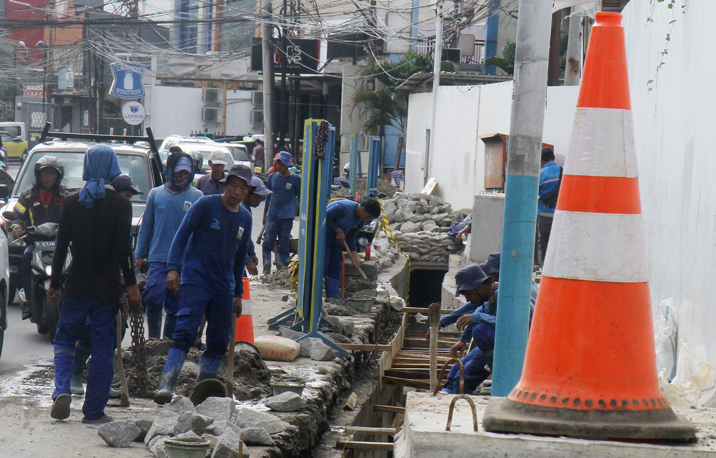 Petugas menggunakan alat berat mengeruk galian untuk pemasangan boks saluran drainase saat perbaikan saluran air di Jalan Benhil,Jakarta, Rabu (15/5/2024).  (BeritaNasional.com/Oke Atmaja)