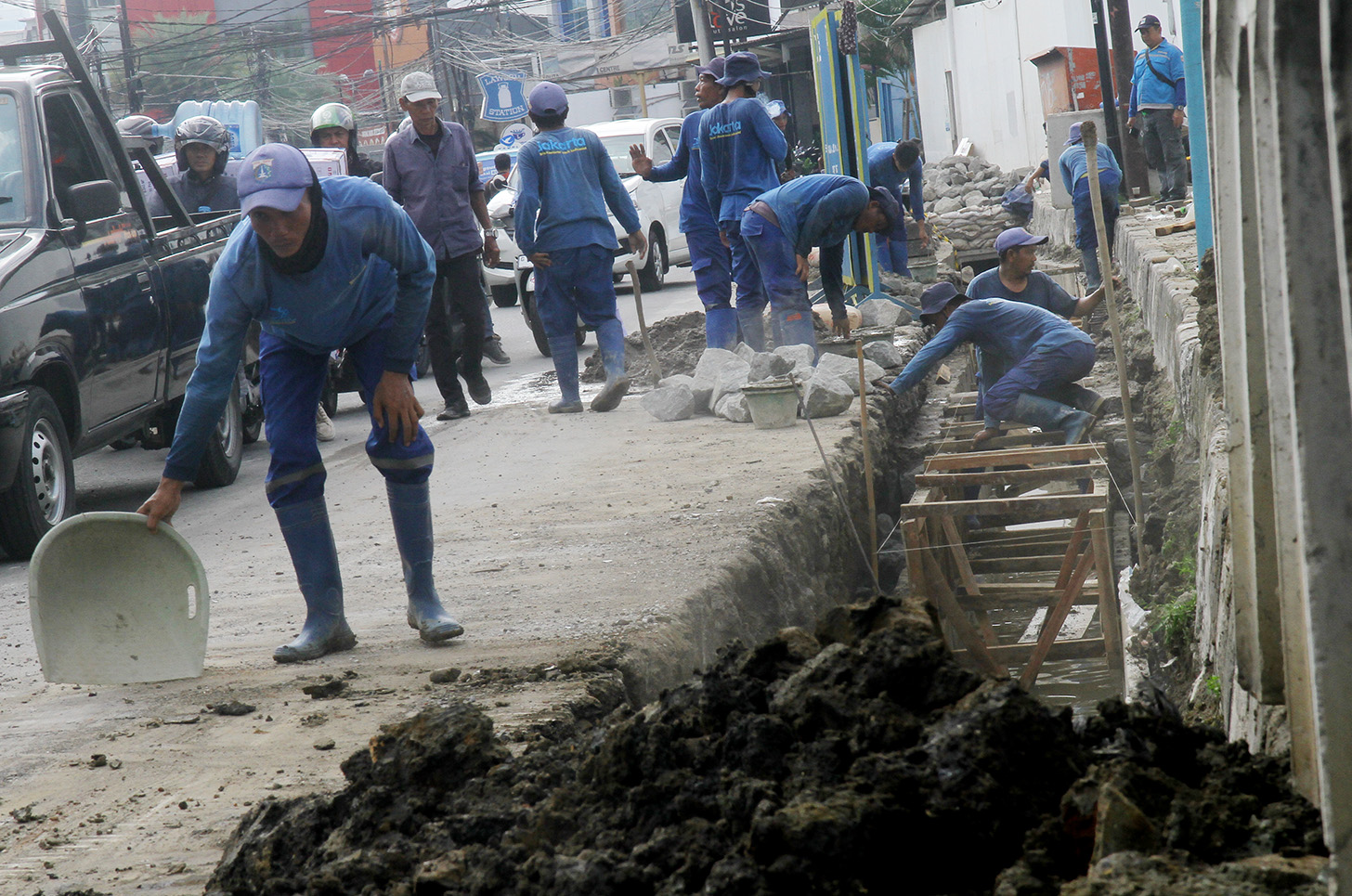 Petugas menggunakan alat berat mengeruk galian untuk pemasangan boks saluran drainase saat perbaikan saluran air di Jalan Benhil,Jakarta, Rabu (15/5/2024).  (BeritaNasional.com/Oke Atmaja)