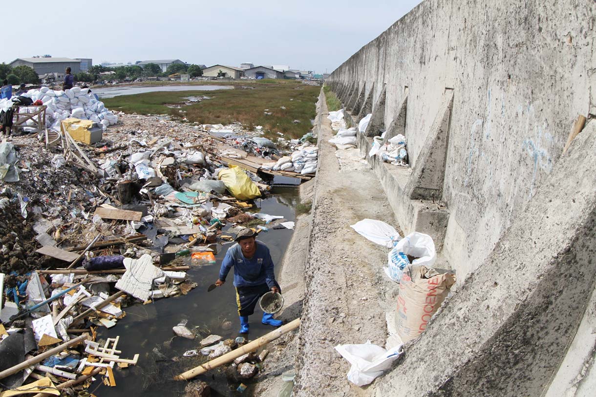 Petugas Suku Dinas Sumber Daya Air (SDA) Jakarta Utara menambal tanggul laut Muara Baru yang bocor di kawasan Muara Baru, Jakarta, Selasa(5/12/2025).  (Beritanasional.com/Oke Atmaja)
