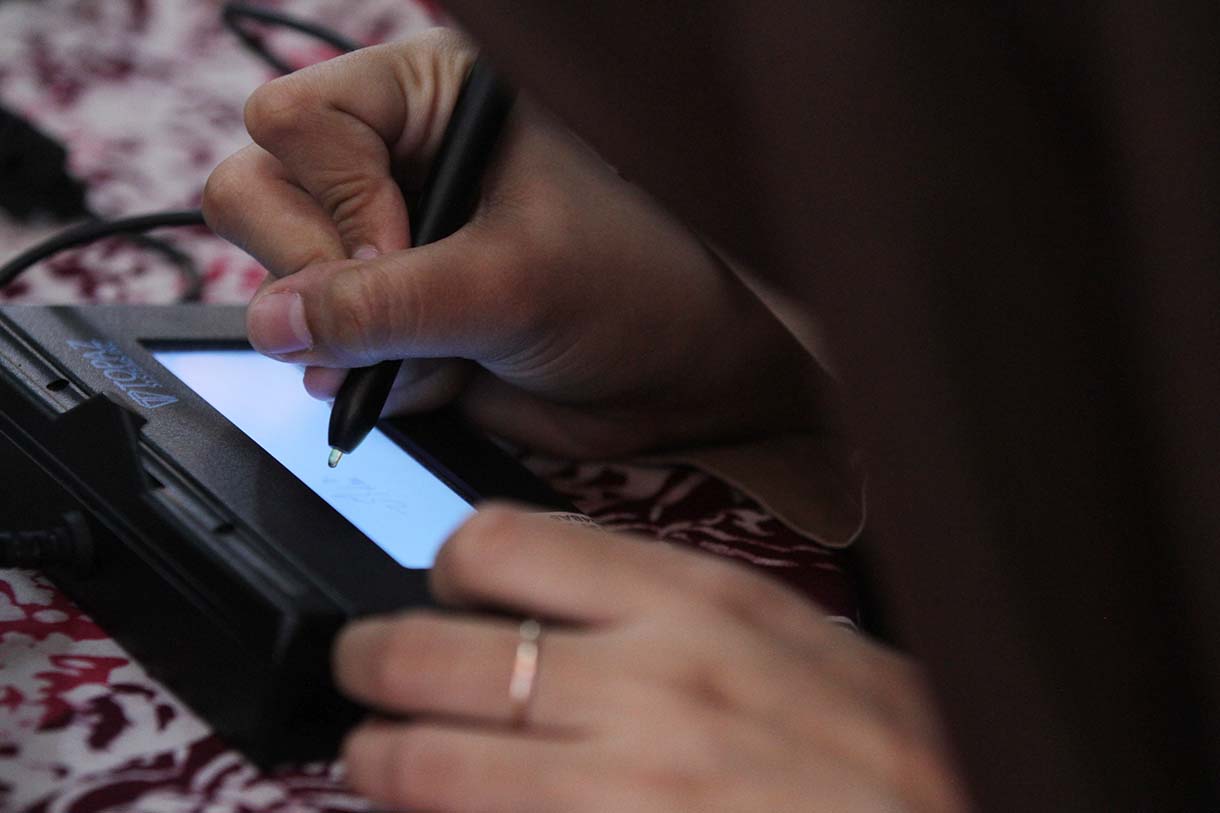 Petugas Suku Dinas Kependudukan dan Catatan Sipil (Sudin Dukcapil) Jakarta Selatan mengarahkan pelajar saat perekaman data KTP elektronik di Madrasah Aliyah Al-Khairiyah, Mampang Prapatan, Jakarta, Rabu (28/8/2025).  (Beritanasional.com/Oke Atmaja)
