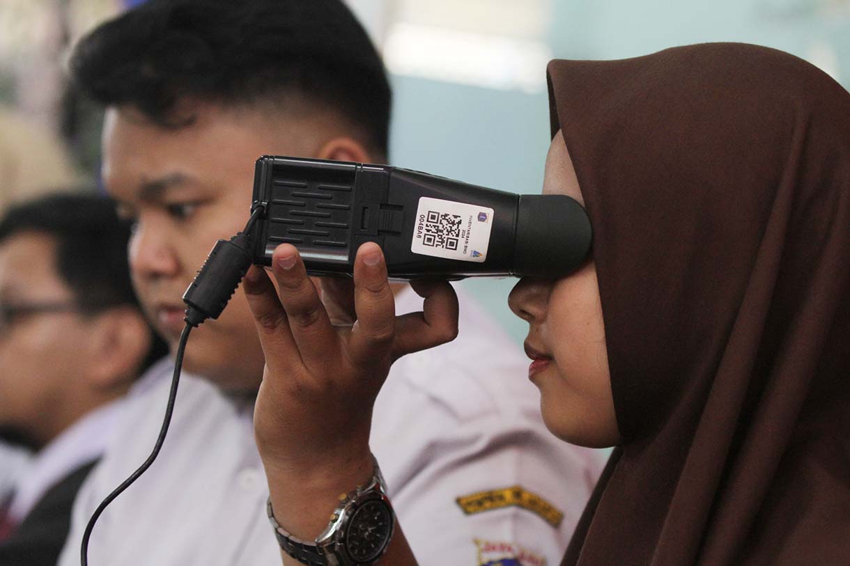 Petugas Suku Dinas Kependudukan dan Catatan Sipil (Sudin Dukcapil) Jakarta Selatan mengarahkan pelajar saat perekaman data KTP elektronik di Madrasah Aliyah Al-Khairiyah, Mampang Prapatan, Jakarta, Rabu (28/8/2025).  (Beritanasional.com/Oke Atmaja)