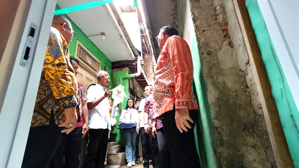 Walikota Jakarta Pusat Arifin (tengah) memberikan kunci rumah simbolis kepada warga di dampingi Nurhelmi Savitri, Camat Menteng ketiga dari kiri, Basri Baco, Wakil Ketua DPRD DKI Jakarta, kedua dari kiri dan Indrawan Prasetyo, Lurah Menteng kedua dari kanan, di Menteng Jaya RT 14/08, Jakarta, Kamis ( 11/12/2025). (Berita nasional.com/Oke Atmaja)