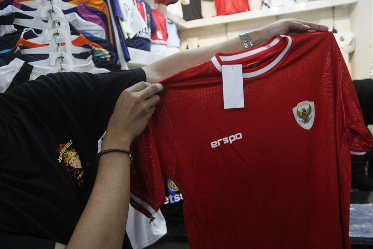 Pedagang merapikan jersey Timnas Indonesia di Pasar Tanah Abang, Jakarta, Sabtu (26/10/2024).(BeritaNasional.com/Oke Atmaja)