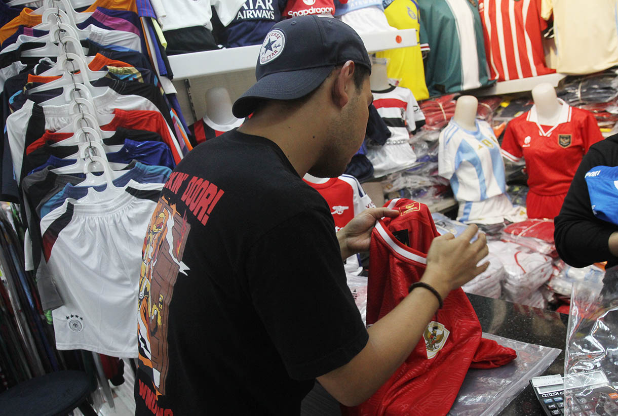 Pedagang merapikan jersey Timnas Indonesia di Pasar Tanah Abang, Jakarta, Sabtu (26/10/2024).(BeritaNasional.com/Oke Atmaja)