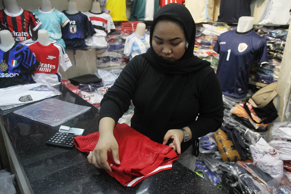 Pedagang merapikan jersey Timnas Indonesia di Pasar Tanah Abang, Jakarta, Sabtu (26/10/2024).(BeritaNasional.com/Oke Atmaja)