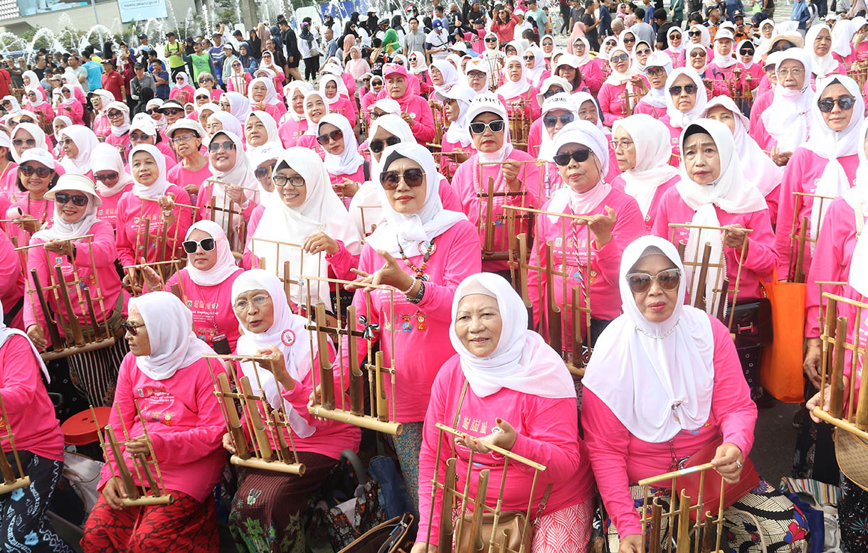 Sejumlah peserta memainkan alat musik angklung saat peringatan ke-15 Hari Angklung Sedunia di kawasan Bundaran HI, Jakarta, Minggu (16/11/2025). (Beritanasional.com/Oke Atmaja)