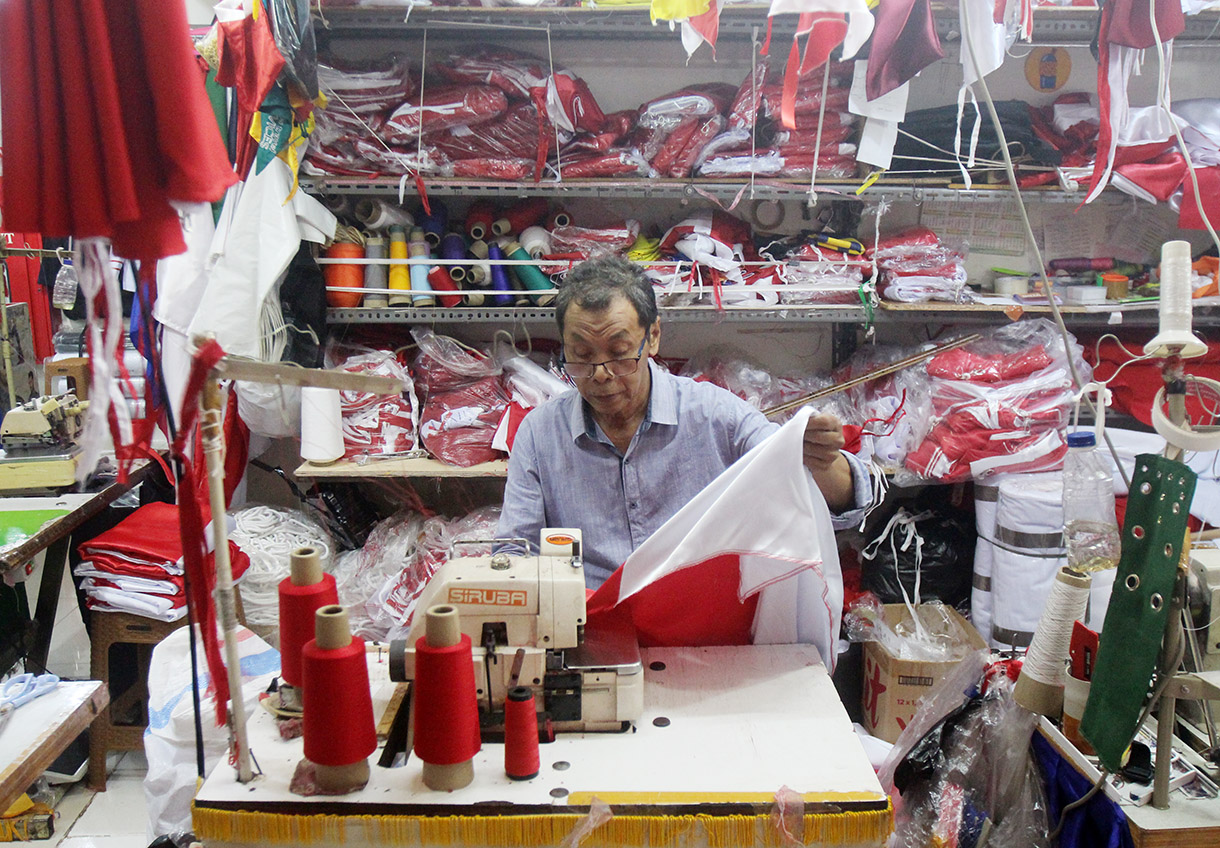 Pekerja menjahit bendera dan rempel di tempat konveksi dan toko di Blok 3 Pasar Senen, Jakarta, Jumat (2/8/2024). (BeritaNasional.com/Oke Atmaja)