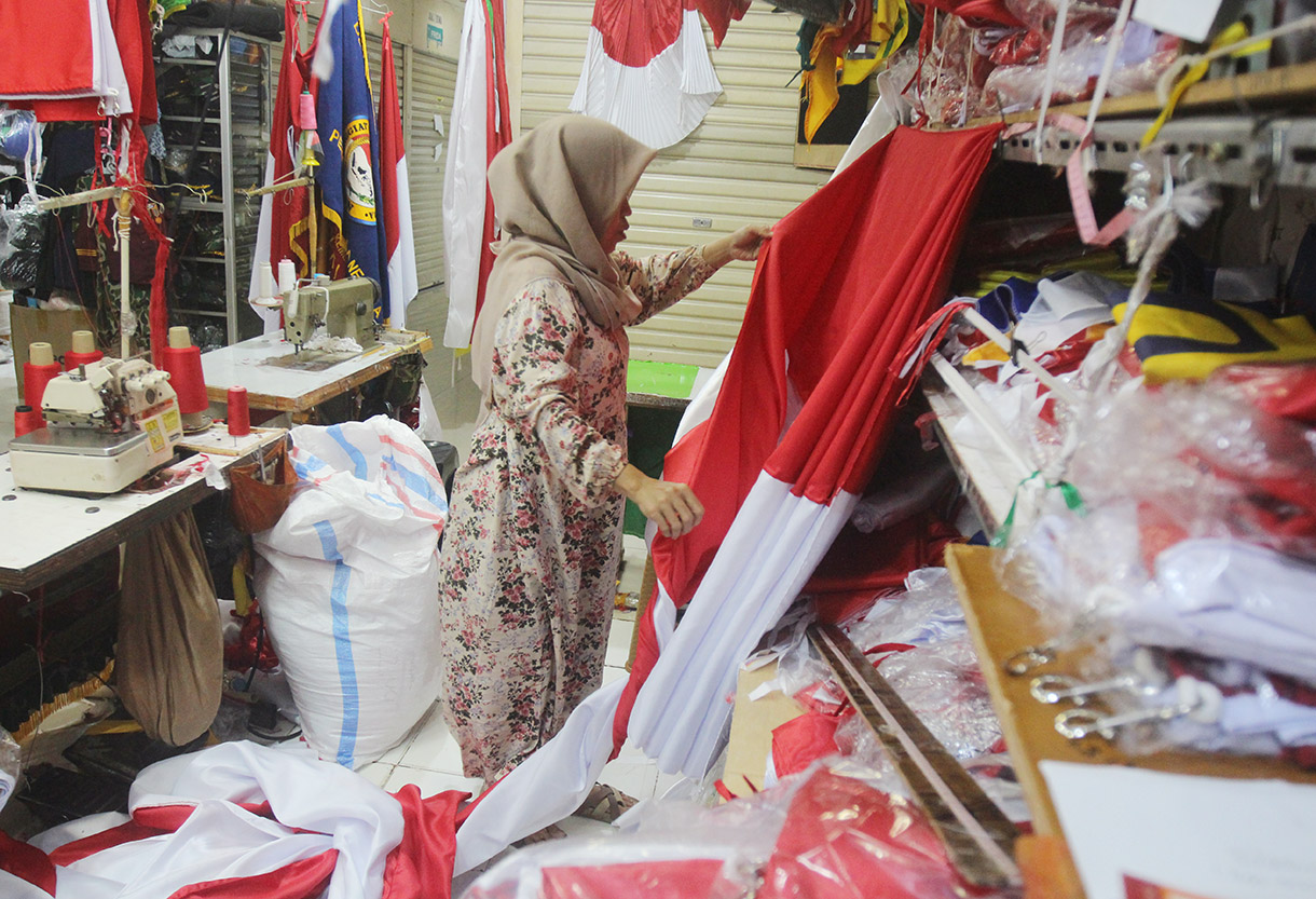 Pekerja menjahit bendera dan rempel di tempat konveksi dan toko di Blok 3 Pasar Senen, Jakarta, Jumat (2/8/2024). (BeritaNasional.com/Oke Atmaja)