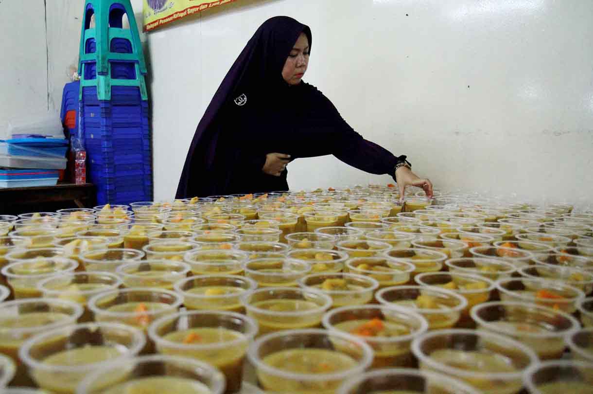 Pedagang menata kolak pisang ubi di tokonya di Pasar jatinegara, Jumat (17/3/2025).(Beritanasional.com/Oke Atmaja)