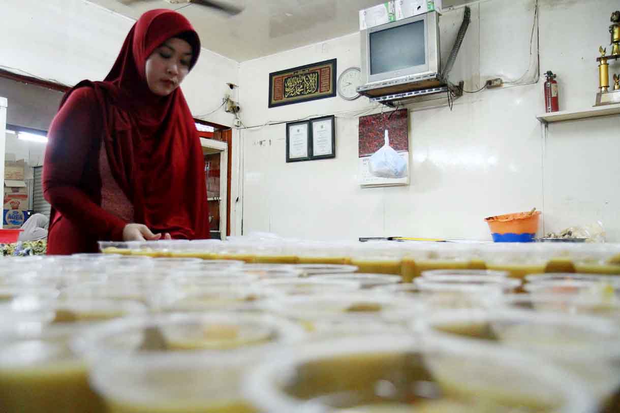 Pedagang menata kolak pisang ubi di tokonya di Pasar jatinegara, Jumat (17/3/2025).(Beritanasional.com/Oke Atmaja)