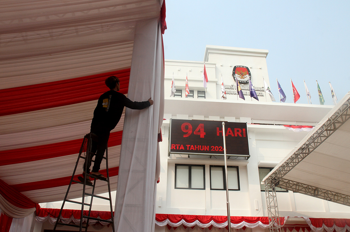 Pekerja memasang tirai di tiang tenda di kantor KPUD DKI Jakarta,Sabtu (24/8/2024).  (BeritaNasional.com/ Oke Atmaja)