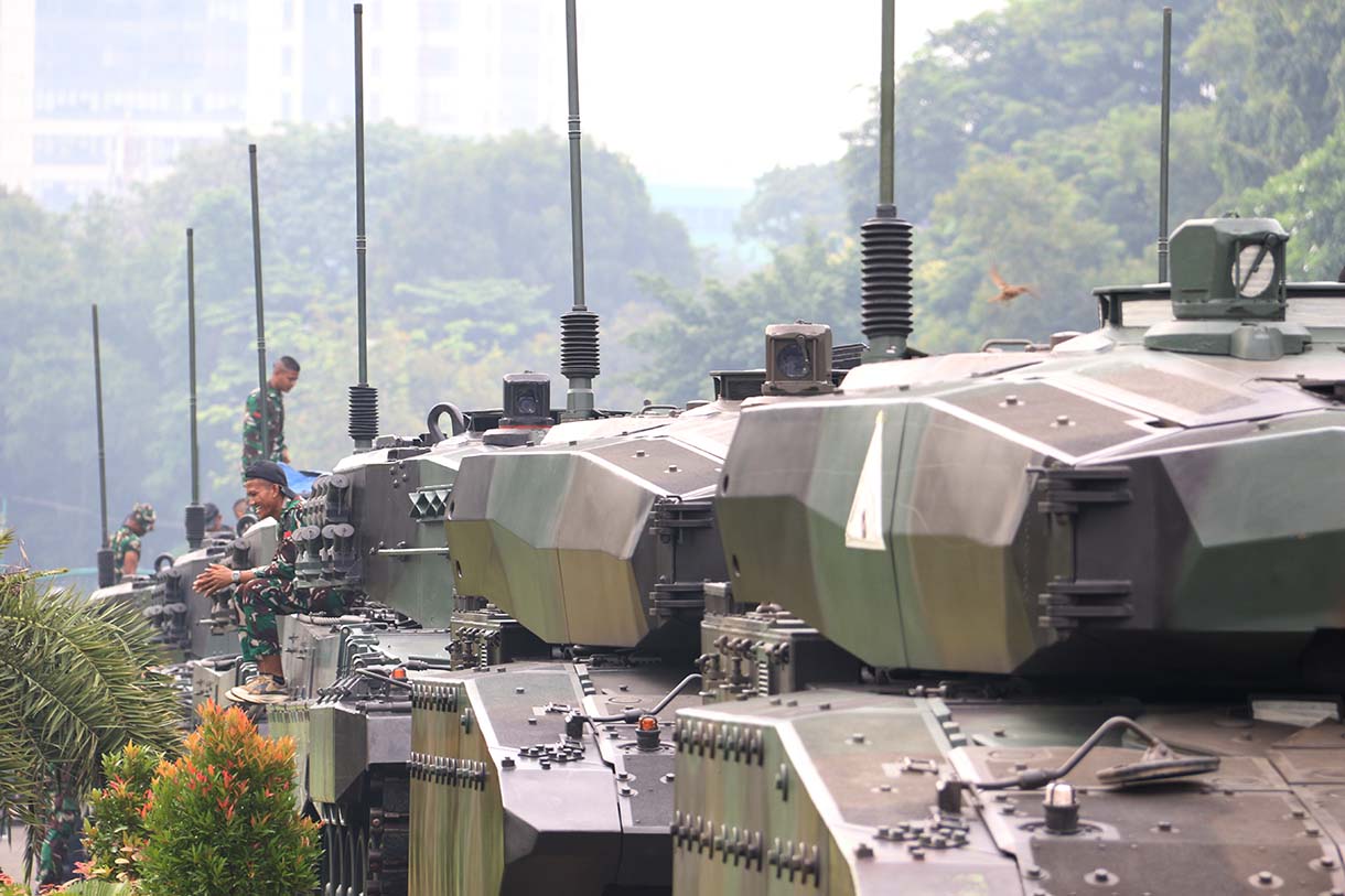 Prajurit TNI melintas di samping kendaraan tempur jenis Panser Anoa milik TNI AD di kawasan Monas, Jakarta, Jumat (19/9/2025). (Beritanasional.com/Oke Atmaja)