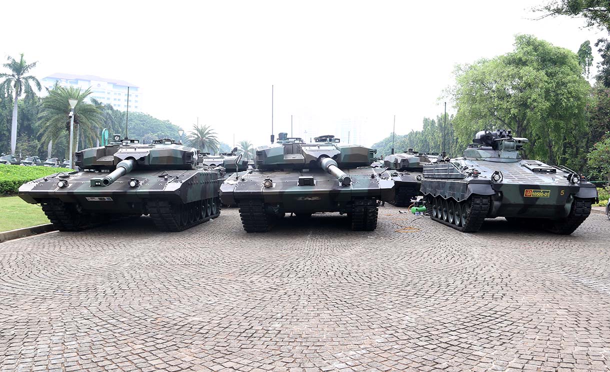 Prajurit TNI melintas di samping kendaraan tempur jenis Panser Anoa milik TNI AD di kawasan Monas, Jakarta, Jumat (19/9/2025). (Beritanasional.com/Oke Atmaja)