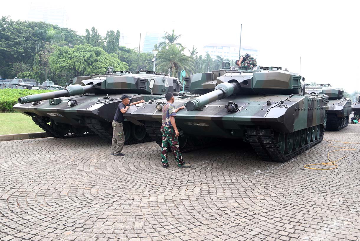 Prajurit TNI melintas di samping kendaraan tempur jenis Panser Anoa milik TNI AD di kawasan Monas, Jakarta, Jumat (19/9/2025). (Beritanasional.com/Oke Atmaja)