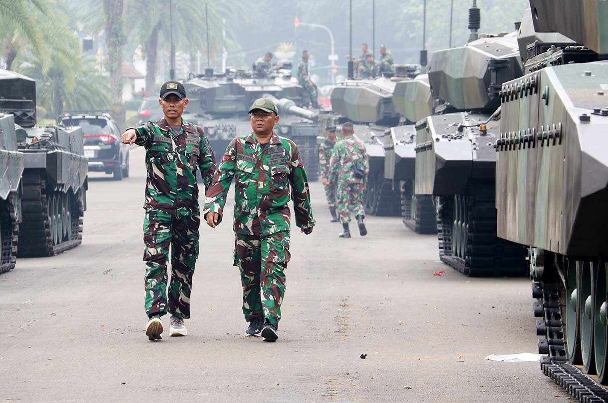 Prajurit TNI melintas di samping kendaraan tempur jenis Panser Anoa milik TNI AD di kawasan Monas, Jakarta, Jumat (19/9/2025). (Beritanasional.com/Oke Atmaja)