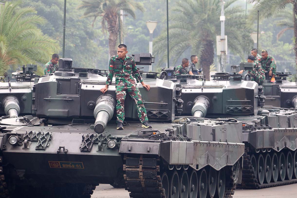 Prajurit TNI melintas di samping kendaraan tempur jenis Panser Anoa milik TNI AD di kawasan Monas, Jakarta, Jumat (19/9/2025). (Beritanasional.com/Oke Atmaja)