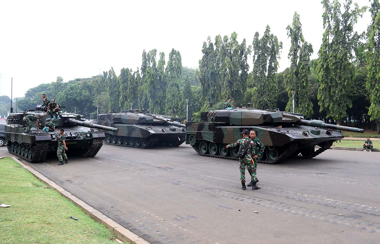 Prajurit TNI melintas di samping kendaraan tempur jenis Panser Anoa milik TNI AD di kawasan Monas, Jakarta, Jumat (19/9/2025). (Beritanasional.com/Oke Atmaja)
