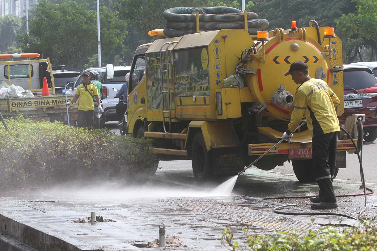 Petugas Dinas Bina Marga membersihkan trotoar di Jalan Jenderal Sudirman, Jakarta, Kamis (4/9/2025).  (Beritanasional.com/Oke Atmaja)