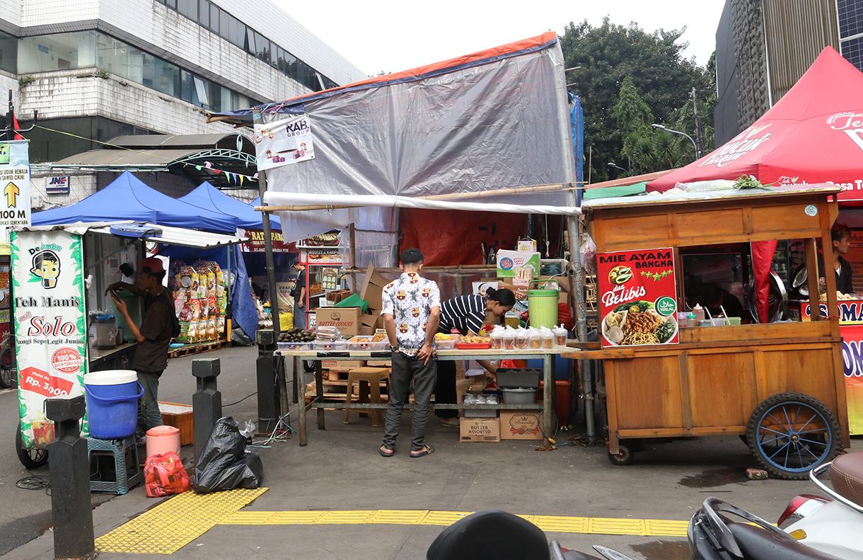 Warga berjalan ditengah lapak pedagang kaki lima (PKL) di trotoar Cikini, Jakarta, Senin (23/2/2026). (Beritanasional.com/Oke Atmaja)