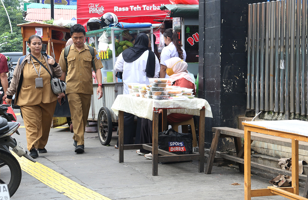 Warga berjalan ditengah lapak pedagang kaki lima (PKL) di trotoar Cikini, Jakarta, Senin (23/2/2026). (Beritanasional.com/Oke Atmaja)