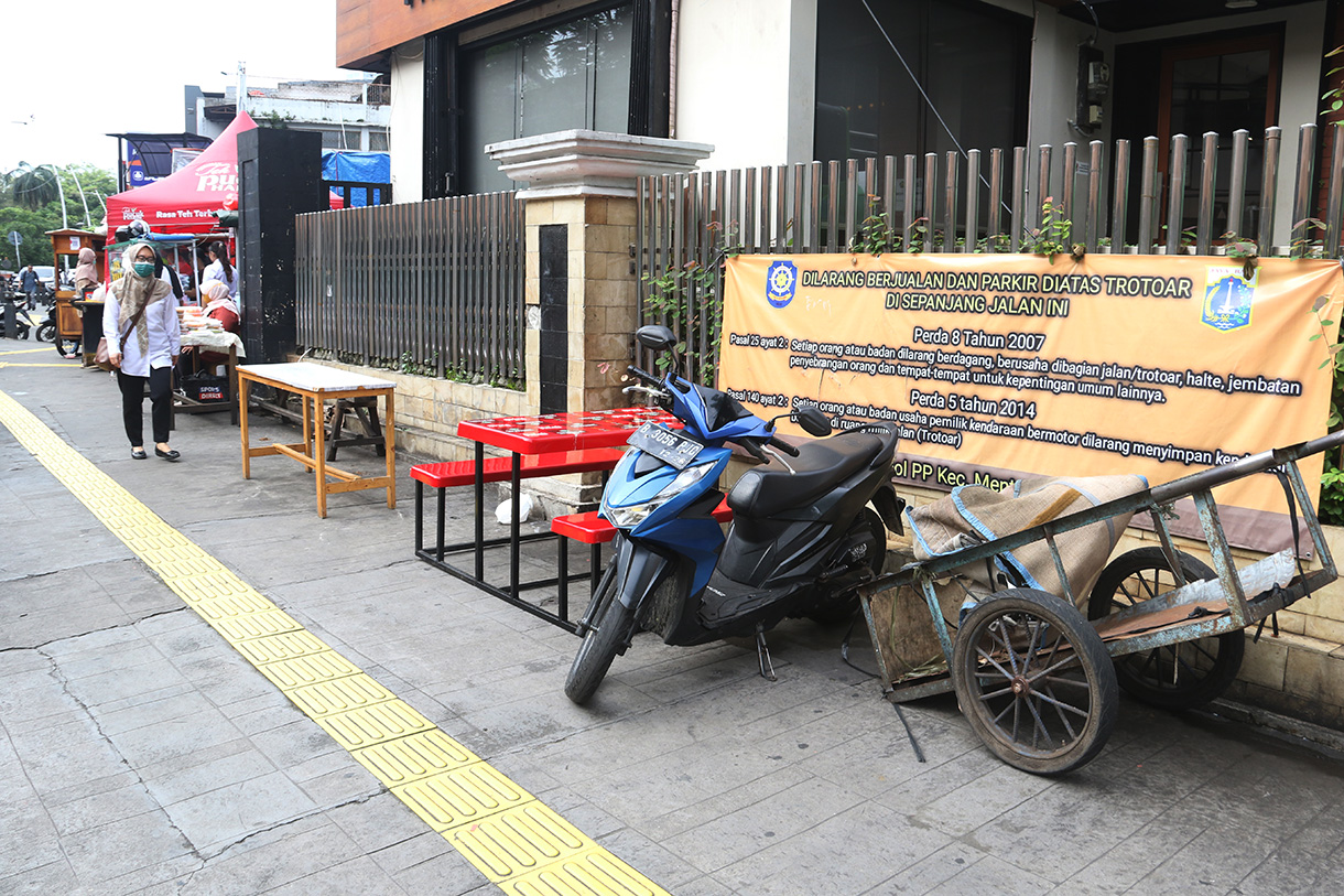 Warga berjalan ditengah lapak pedagang kaki lima (PKL) di trotoar Cikini, Jakarta, Senin (23/2/2026). (Beritanasional.com/Oke Atmaja)