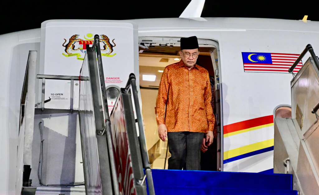 PM Malaysia Anwar Ibrahim tiba di Indonesia Perdana Menteri Malaysia Anwar Ibrahim (tengah) didampingi Mendagri Tito Karnavian (kiri) dan Menlu Sugiono (kanan) berjalan saat tiba di Lanud Halim Perdanakusuma, Jakarta, Senin (28/7/2025). (Beritanasional.com/ Biro Pers)