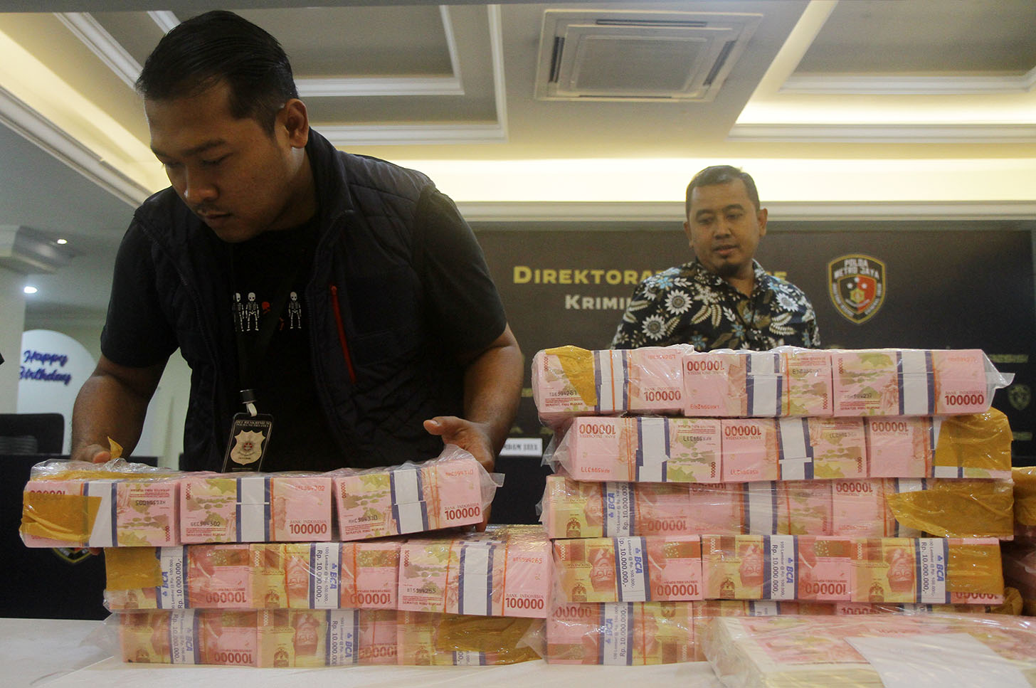 Petugas menatah uang palsu saat konferensi pers rilis kasus uang palsu di Polda Metro Jaya, Jum'at (21/6/2024). (BeritaNasional.Com/Oke Atmaja)