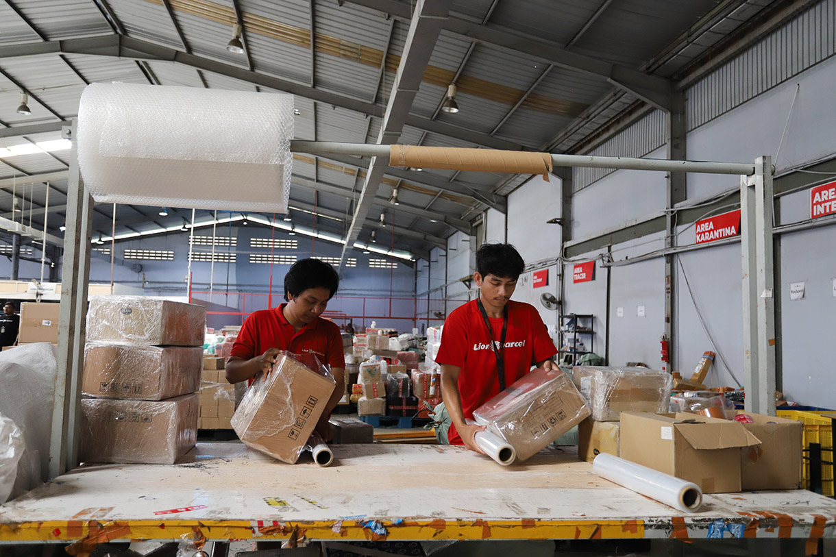 Petugas menyortir paket untuk dikirim ke pelanggan di Mega Hub Lion Parcel, Kota Tangerang, Banten, Jumat(20/12/2024). (BeritaNasional.com/Oke Atmaja)