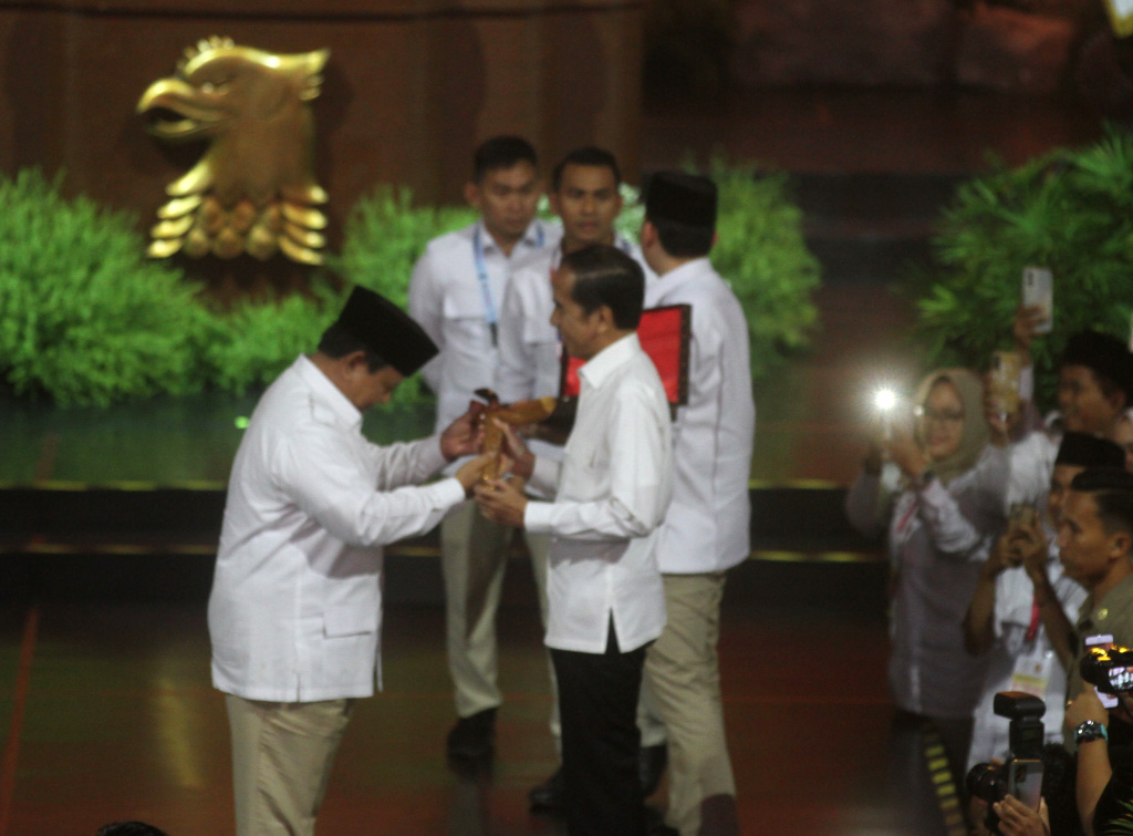 Presiden Prabowo Subianto (kiri) yang juga Ketua Umum Partai Gerindra memberikan keris emas ke Presiden ke-7 Joko Widodo (kedua kanan) saat menghadiri perayaan HUT ke-17 Partai Gerindra di Sentul International Convention Center, Bogor, Jawa Barat, Sabtu (15/2/2025). (Berita Nasional.com/Oke Atmaja)