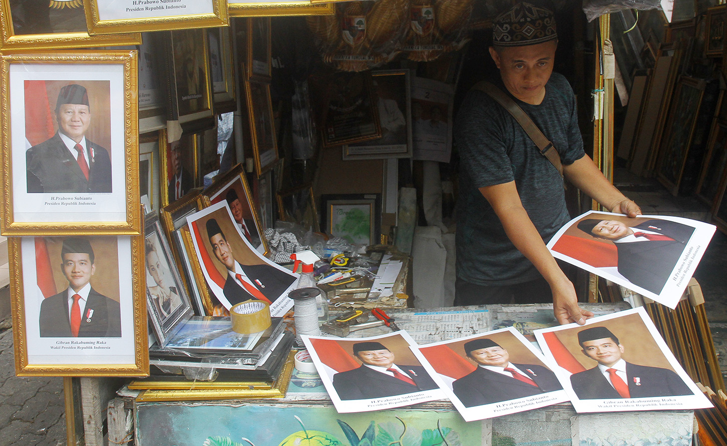 Pedagang menata foto pasangan Prabowo-Gibran sebagai Presiden dan Wakil Presiden 2024-2029 di kawasan Pasar Baru, Jakarta, Kamis (25/4/2024). (BeritaNasional.com/Oke Atmaja)