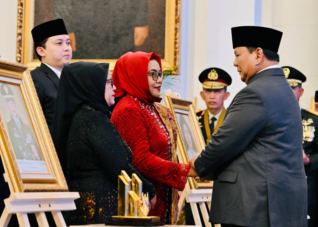 Presiden Prabowo Subianto menyalami Istri almarhum K.H. Abdurrahman Wahid, Sinta Nuriyah (kedua kiri) dan anaknya Yenny Wahid (kiri) saat penganugerahan gelar pahlawan nasional di Istana Negara, Jakarta, Senin (10/11/2025).  (Biropers)