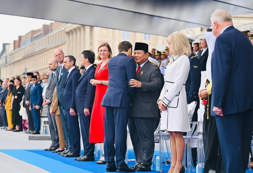 Presiden Prabowo hadiri Parade Bastille Day Presiden Prabowo Subianto (kedua kanan) berjabat tangan dengan Presiden Prancis Emmanuel Macron (ketiga kanan) disaksikan istri Brigitte Macron (kanan) saat meghadiri parade Bastille Day di jalan Champs-Elysees, Paris, Prancis, Senin (14/7/2025). (Beritanasional.com/Biropers)
