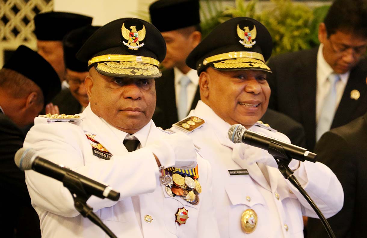 Presiden Prabowo Subianto (kanan) memasang tanda jabatan kepada Gubernur Papua Mathius Fakhiri (kiri) disaksikaan Wakil Gubernur Aryoko Rumaropen (kedua kiri) saat acara pelantikan di Istana Negara, Jakarta, Rabu (8/10/2025).  (Beritanasional.com/Oke Atmaja)