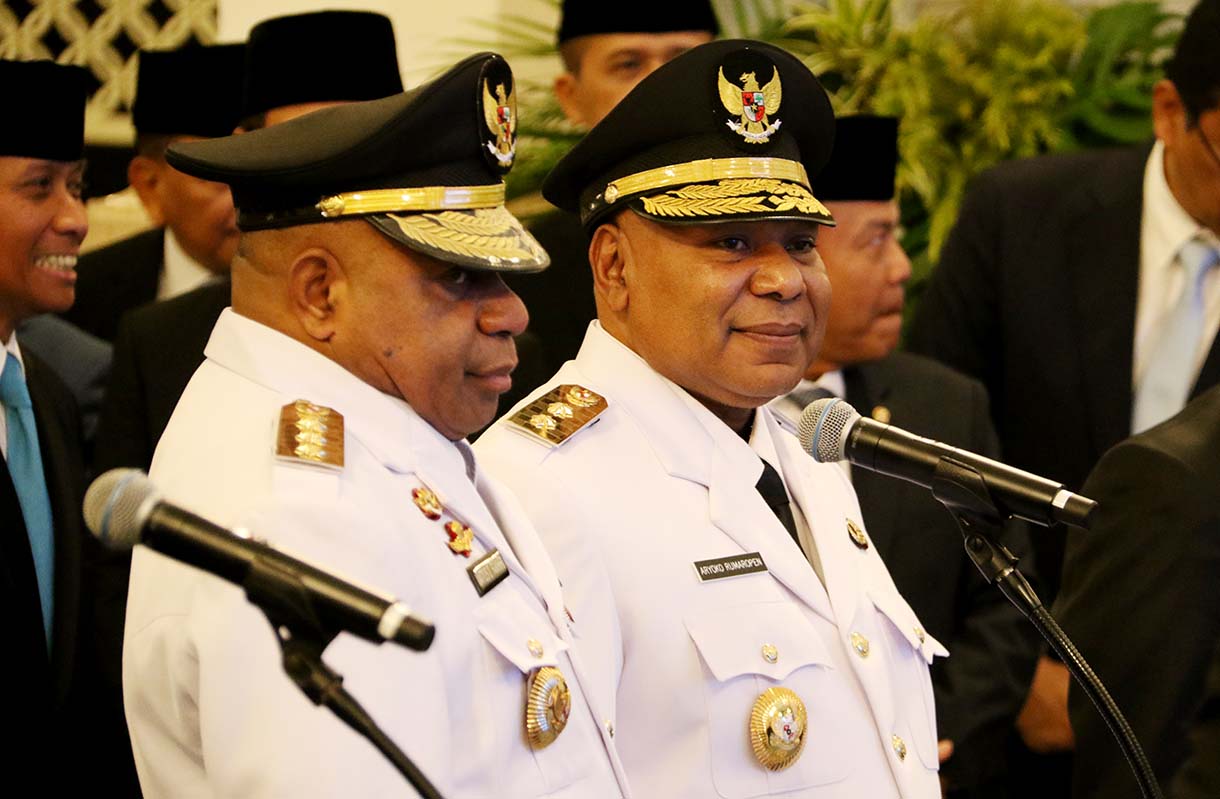 Presiden Prabowo Subianto (kanan) memasang tanda jabatan kepada Gubernur Papua Mathius Fakhiri (kiri) disaksikaan Wakil Gubernur Aryoko Rumaropen (kedua kiri) saat acara pelantikan di Istana Negara, Jakarta, Rabu (8/10/2025).  (Beritanasional.com/Oke Atmaja)